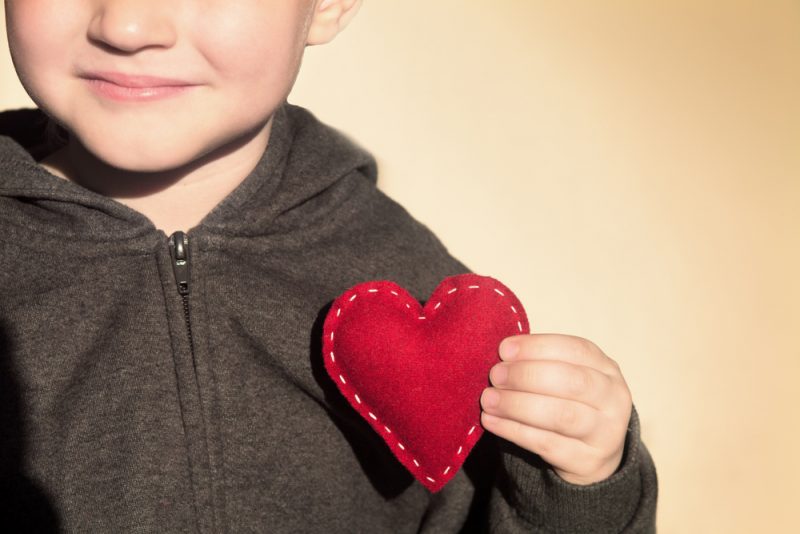 Child holding a stitched fabric heart