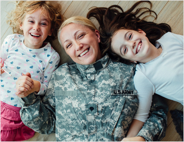 Uniformed mom lying on floor with daughters