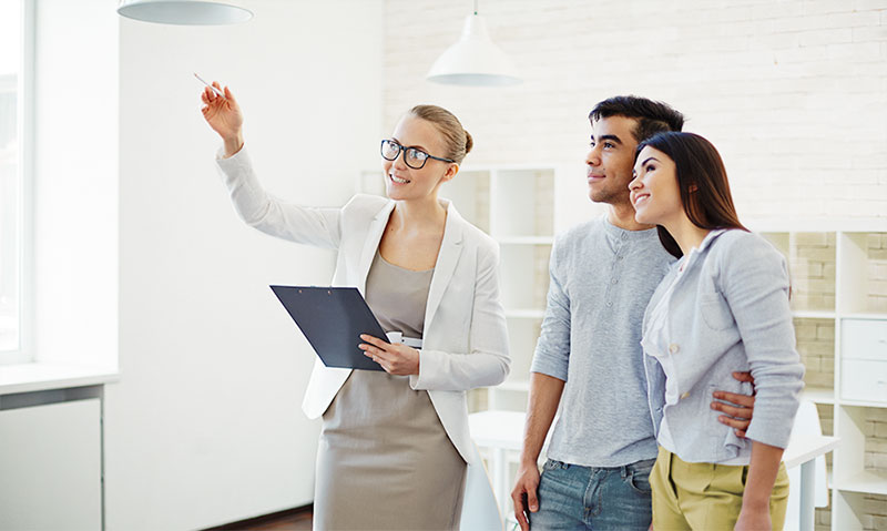 buying-house-while-in-debt Realtor showing aspects of home to couple