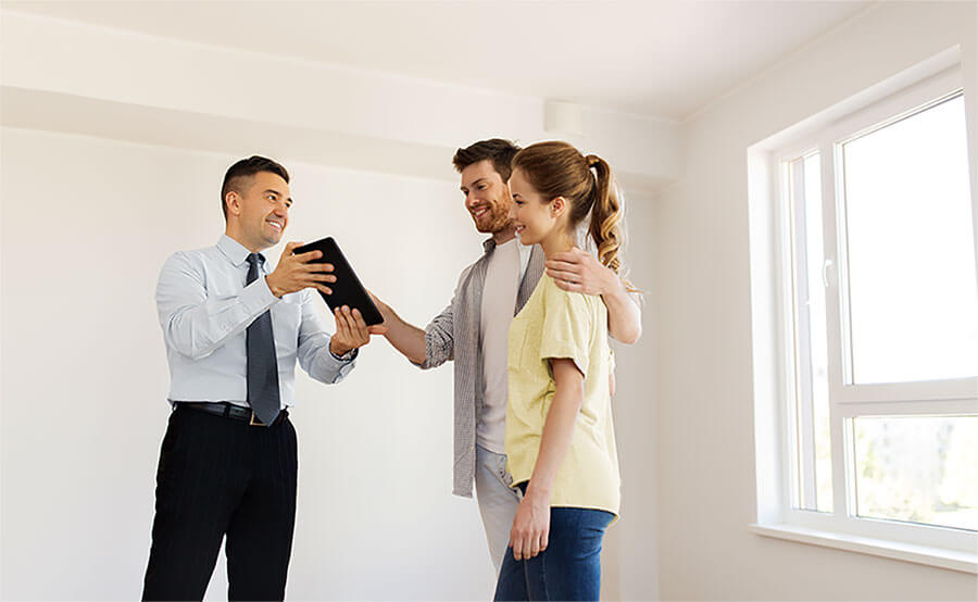 Realtor showing home options to couple on tablet