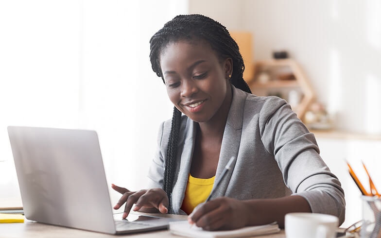 ten-essential-resources Young woman making notes on personal finances from laptop