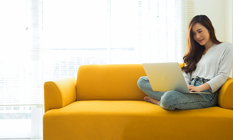 Young woman using laptop on couch