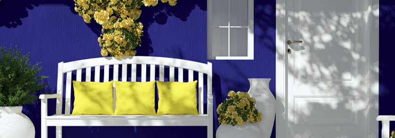Porch of blue house with white bench and yellow flowers