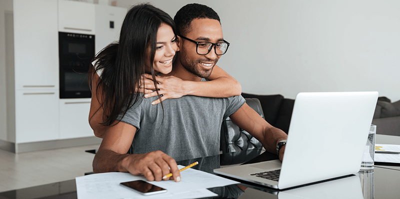 Happy couple working on laptop