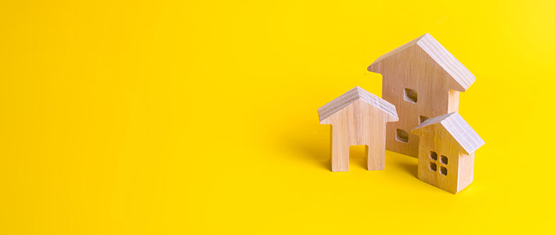 Collection of wooden house ornaments on yellow background