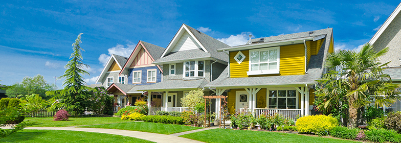 Street view of yellow home in neighborhood