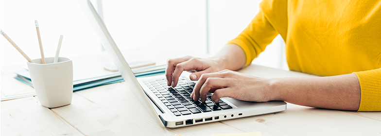 Man at desk typing on laptop