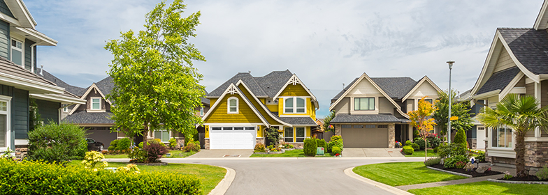 Street view of yellow home in neighborhood