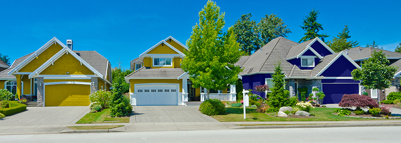 Street view of yellow home in neighborhood