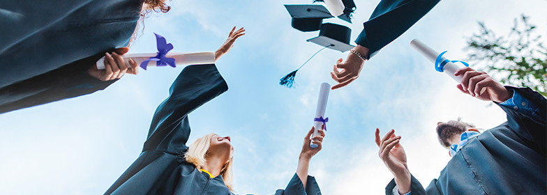 GGScholarship-PR Group of students throwing graduation caps in the air