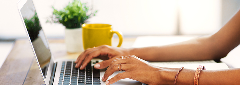 Woman at desk typing on laptop