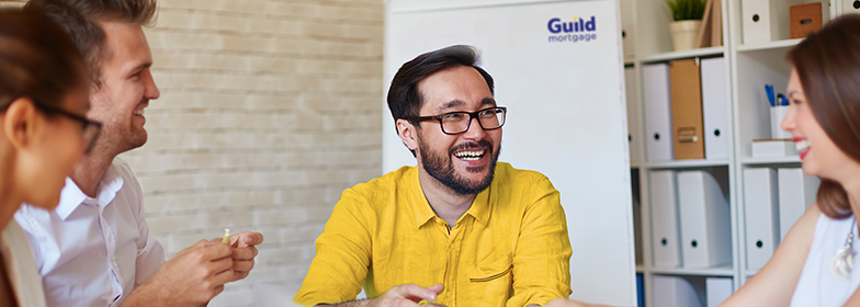 Smiling man in meeting with coworkers.