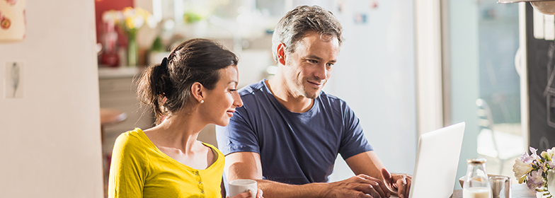 Woman and man looking at a laptop together