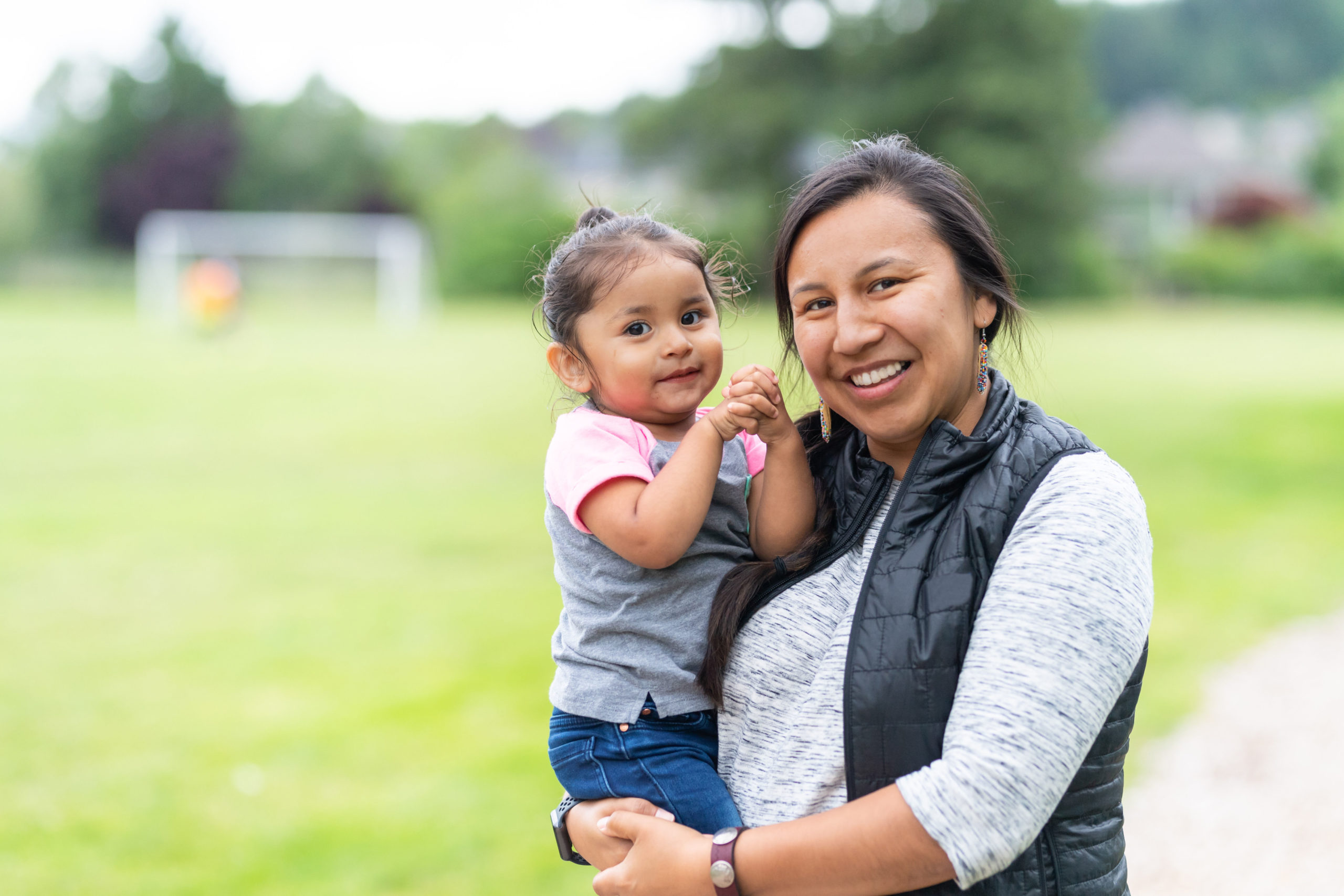 Smiling Native American mother and daughter outside