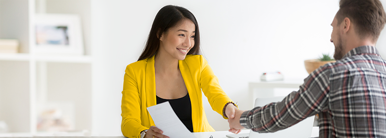 A woman shaking hand after signing a deal