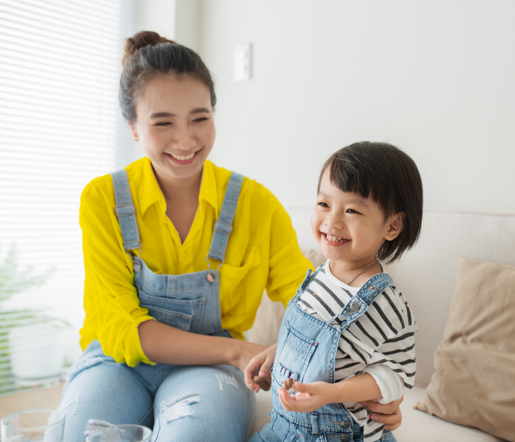 Smiling mother and daughter on couch