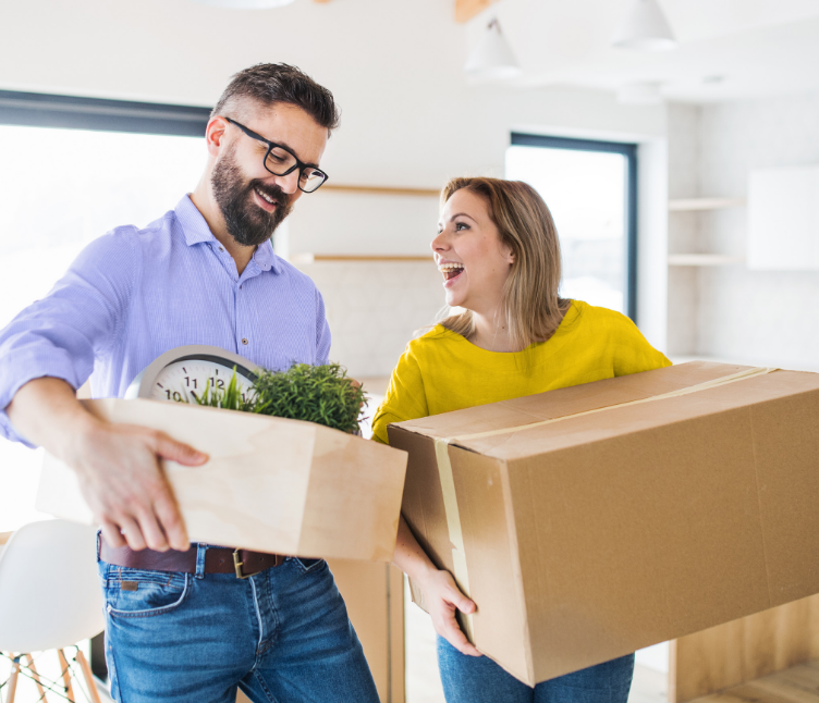 Happy couple moving in with boxes