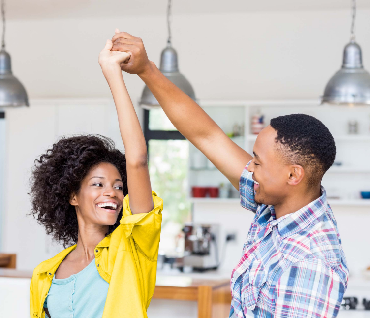 Smiling couple dancing in kitchen