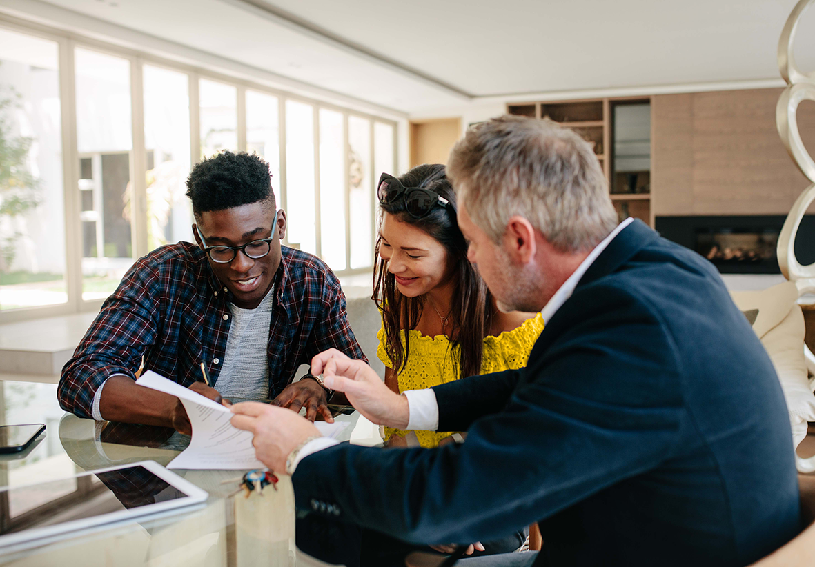 photo landscape young couple signing loan documents in branchwith mortgage professional Couple meeting with loan officer