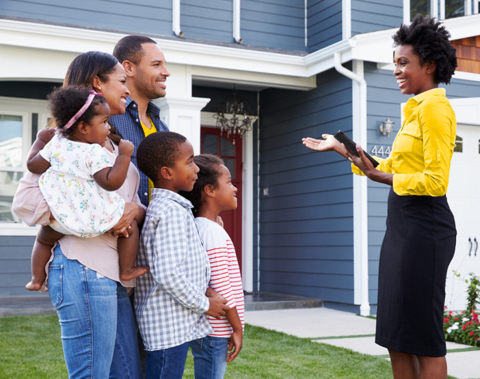 A real estate agent showing a family a home.