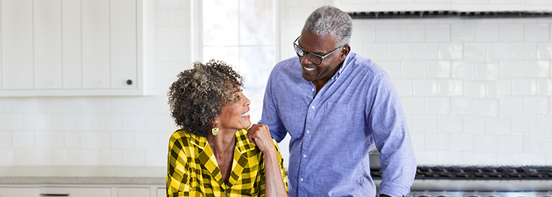 An elderly couple smiling at each other