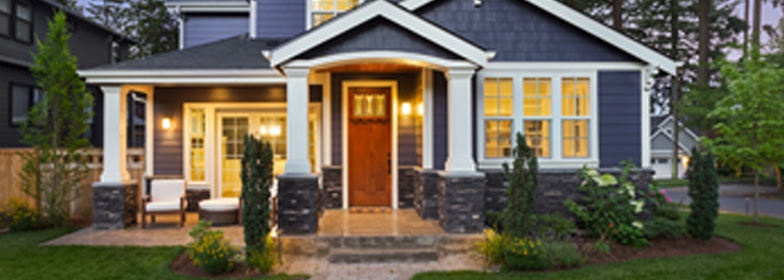 blog-facts-about-houses View of blue house from front path with exterior lights on at sunset