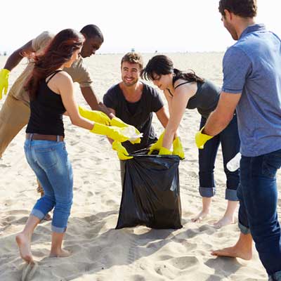 Group of people picking garbage off a beach