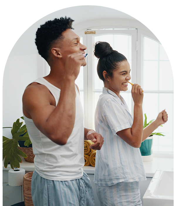 Smiling young couple brushing their teeth
