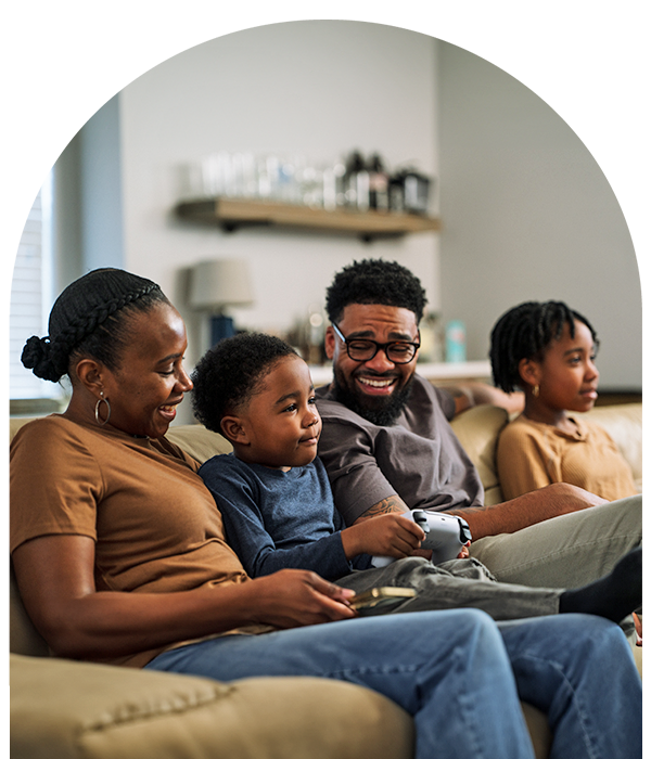 Family laughing on couch together