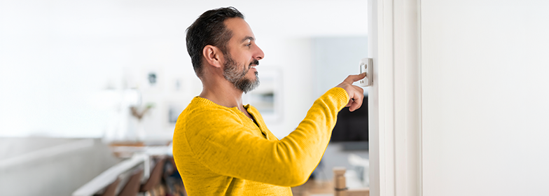 Man changing thermostat in home