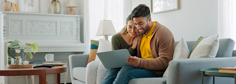 Blog – When should I use my home equity Smiling couple looking at laptop in home